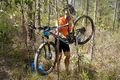 Bush mechanic using tree for bicycle repair