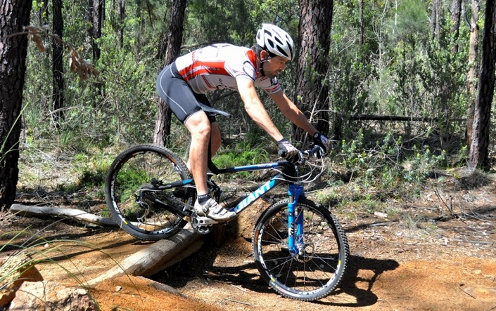 rolling down a small drop on a mountain bike