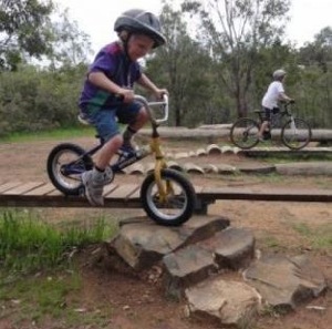 Child riding bike down rocks