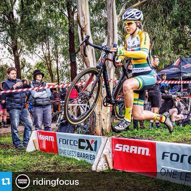Lisa Jacobs jumps with her CX bike over a race course barrier