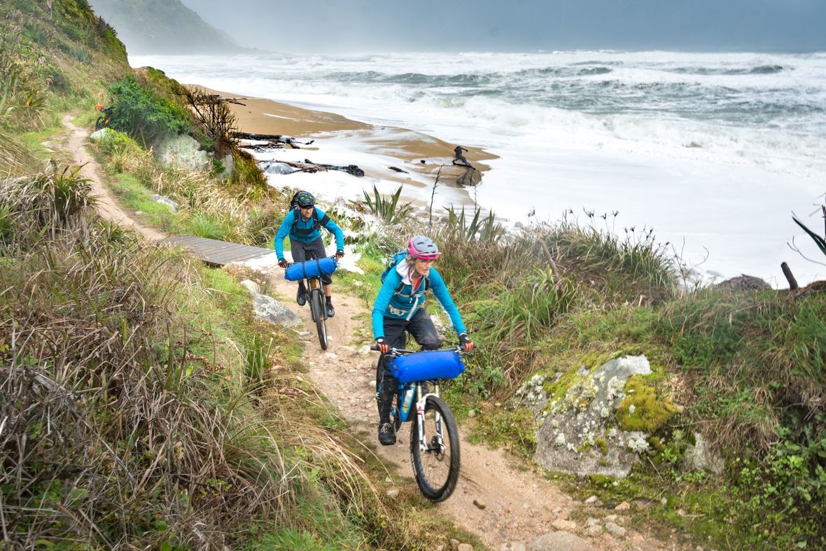 Discover the awesome Heaphy Track Cyclists riding on track next to the ocean